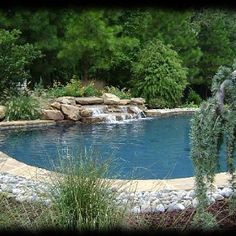 an outdoor pool surrounded by rocks and plants