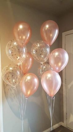 a bunch of pink and white balloons in the shape of hearts on a table next to a door