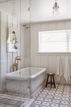 a bathroom with a white tub and black and white floor