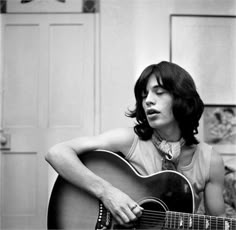 black and white photograph of a woman playing an acoustic guitar