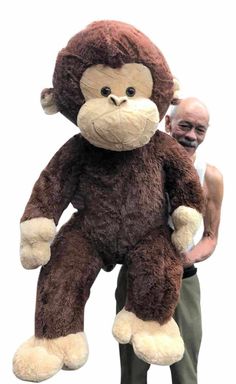 a man standing next to a giant stuffed monkey