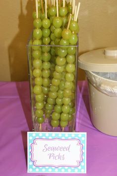 grapes are arranged in a vase with toothpicks