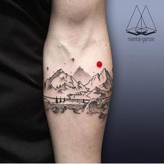 a man with a tattoo on his arm that has mountains and a red dot in the middle