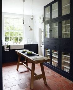 a kitchen with black cabinets and red tile flooring on the walls is shown in an instagram