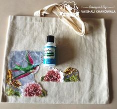 a tote bag with flowers on it next to a bottle of deodorant