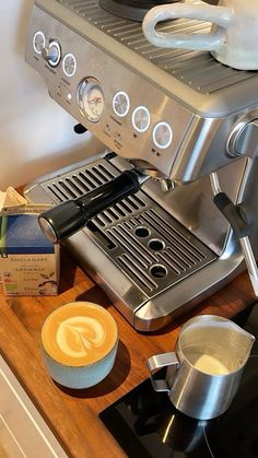 an espresso machine sitting on top of a counter next to a box of coffee