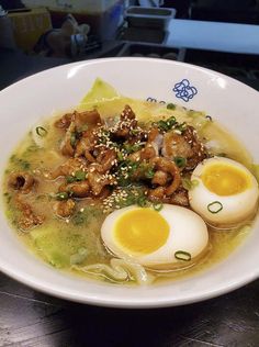 a white bowl filled with soup and hard boiled eggs