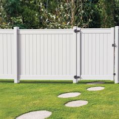 a white fence with stepping stones in the grass