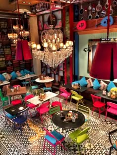 colorful tables and chairs in a restaurant with chandelier