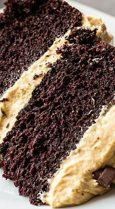 a slice of chocolate cake with peanut butter frosting on a white plate, ready to be eaten