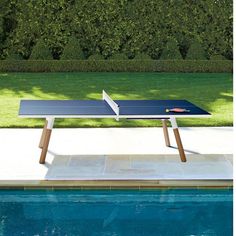 a ping pong table sitting next to a swimming pool