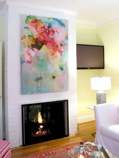 a living room filled with furniture and a fire place under a painting on the wall