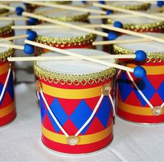 several drums with sticks sticking out of them sitting on a white tablecloth covered table