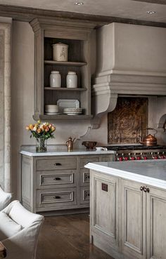 a kitchen with gray cabinets and white counter tops