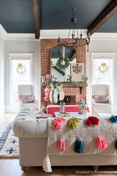 the living room is decorated with pom - poms and an old brick fireplace