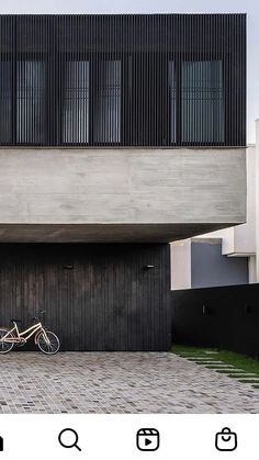 a bike parked in front of a building with black shutters on the doors and windows