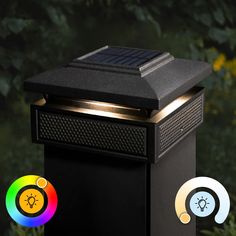 a solar powered light on top of a black box with two different colored lights around it