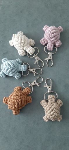 six crocheted animals are shown in different colors and sizes on a gray surface