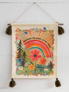 a banner hanging on the wall with flowers and trees