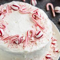 a cake with white frosting and candy canes