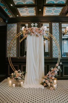 a wedding ceremony setup with flowers and candles on the floor in front of a mirror