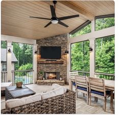 a living room filled with furniture and a flat screen tv mounted on the wall next to a fire place