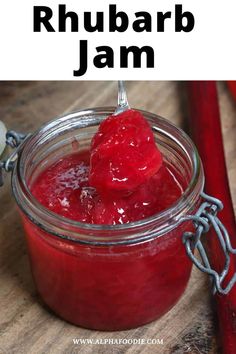 a jar filled with raspberry jam on top of a wooden table