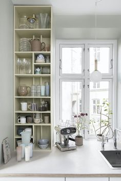 a kitchen counter with dishes and cups on it