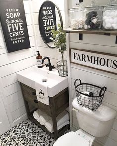 a white toilet sitting next to a sink under a mirror in a bathroom with black and white tiles on the floor