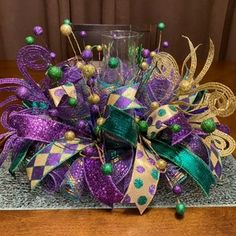 a close up of a purple and green bow on a table