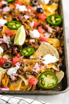 a tray filled with taco salad and tortilla chips on top of a table