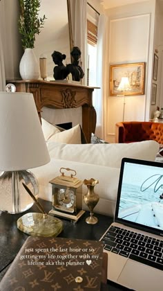 an open laptop computer sitting on top of a desk next to a lamp and other items