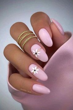 a woman's hand with pink manies and white flowers on the tip of her nails