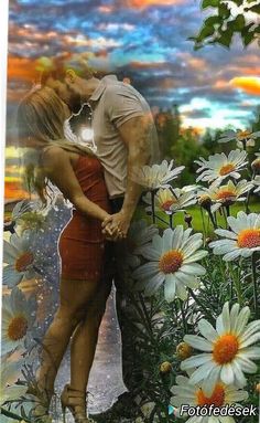 a man and woman are kissing in front of daisies with the sky behind them