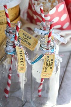 three empty glass bottles with red and white striped straws in them sitting on a table