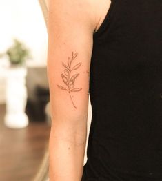 a woman's arm with a small tattoo of a plant on the left side of her arm