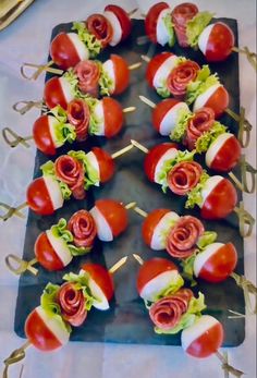 many tomatoes and lettuce on skewers with toothpicks in them