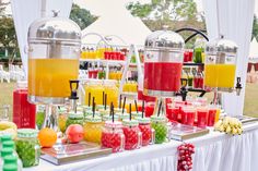 a buffet table filled with lots of different types of drinks and fruit on top of it