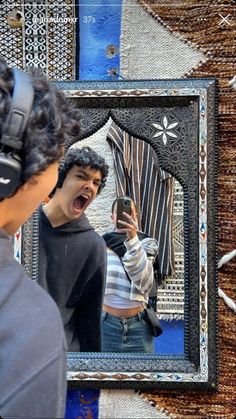 a man taking a selfie in front of a mirror with his mouth wide open