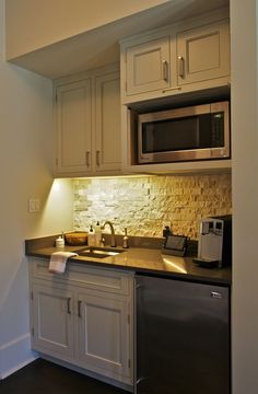 a kitchen with white cabinets and silver appliances