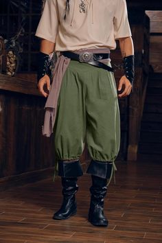 a man dressed in pirate garb standing on a wooden floor with his hands in his pockets