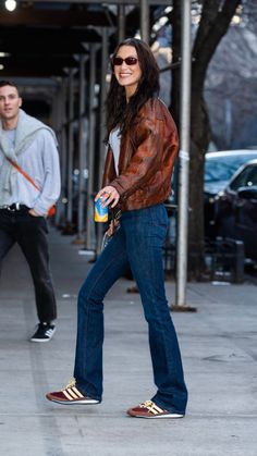 a woman walking down the street with her hand in her pocket