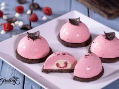 four desserts on a white plate with chocolate and raspberry frosting in the middle