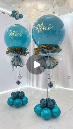 two blue balloons with the words mera on them are in front of a white wall