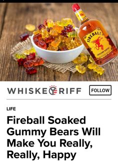 a bowl of gummy bears next to a bottle of whiskey