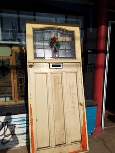 an old wooden door with stained glass on top