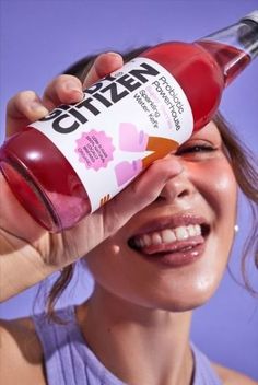 a woman holding a bottle of water up to her face