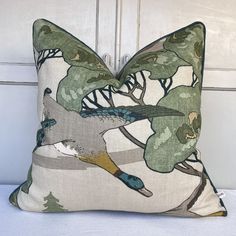 a decorative pillow with birds and trees on it