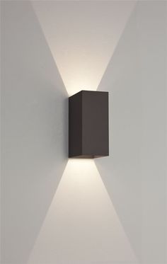 a wall mounted light on the side of a white wall