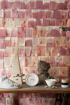 there are many different items on the table in front of this wallpapered room